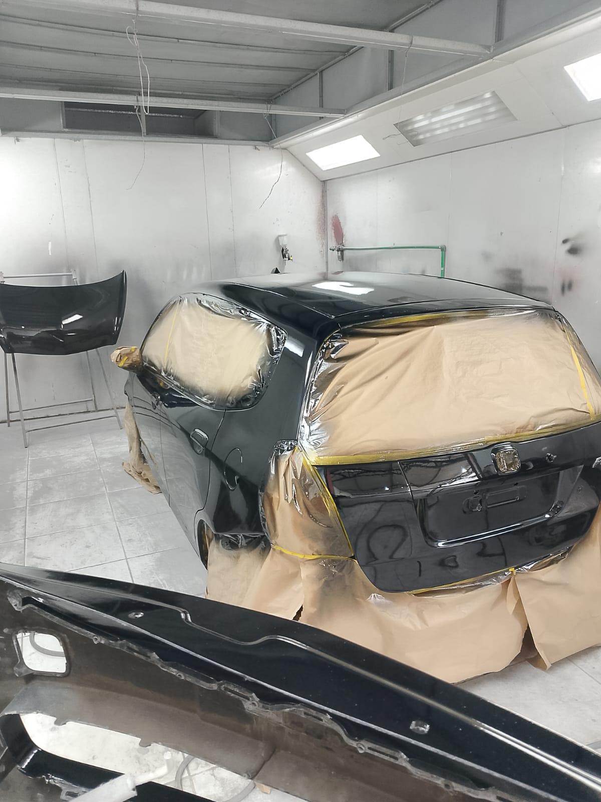 Traseira de veículo em processo de pintura
